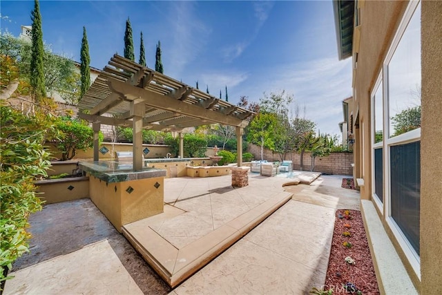 view of patio with an outdoor hangout area, an outdoor kitchen, and a pergola