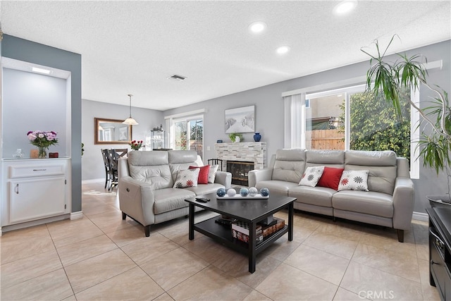 tiled living room featuring a textured ceiling