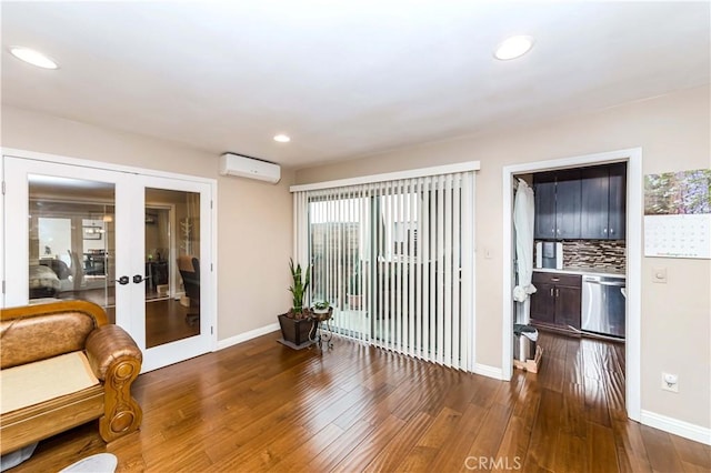 sitting room featuring an AC wall unit, french doors, and dark wood-type flooring