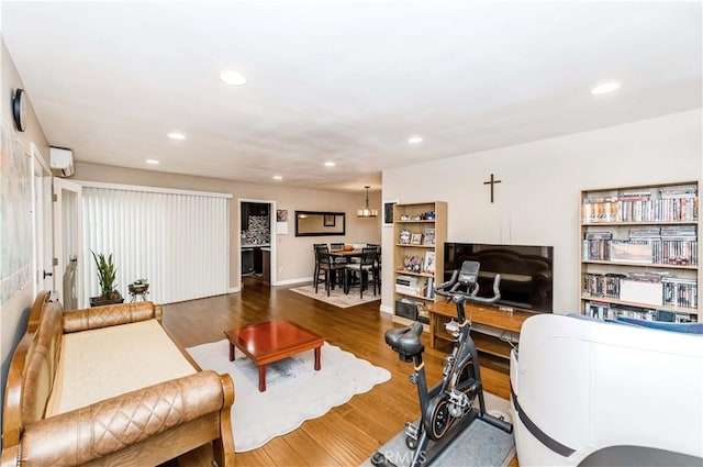 living room featuring hardwood / wood-style flooring and a wall mounted AC