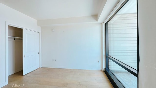 unfurnished bedroom featuring a closet and light wood finished floors