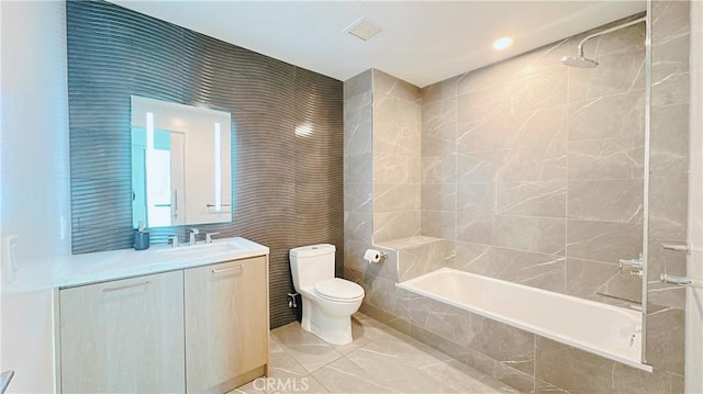 full bath featuring tiled shower / bath combo, toilet, tile walls, visible vents, and vanity