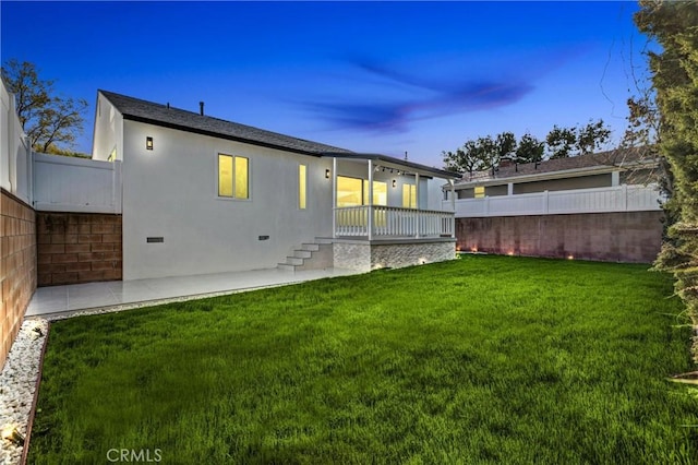 back of property featuring a patio area, fence, a lawn, and stucco siding