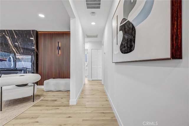 corridor with light wood-style flooring, visible vents, baseboards, and recessed lighting