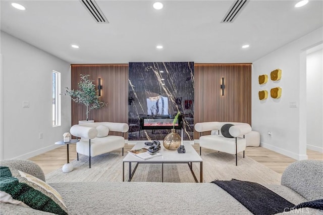 living area with light wood finished floors, visible vents, and recessed lighting