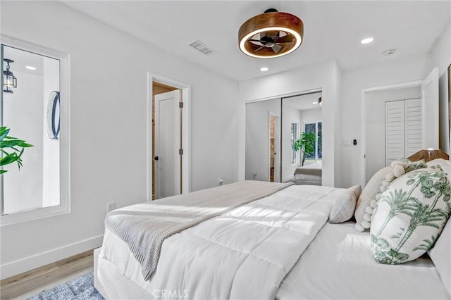 bedroom with recessed lighting, a closet, visible vents, light wood-style floors, and baseboards