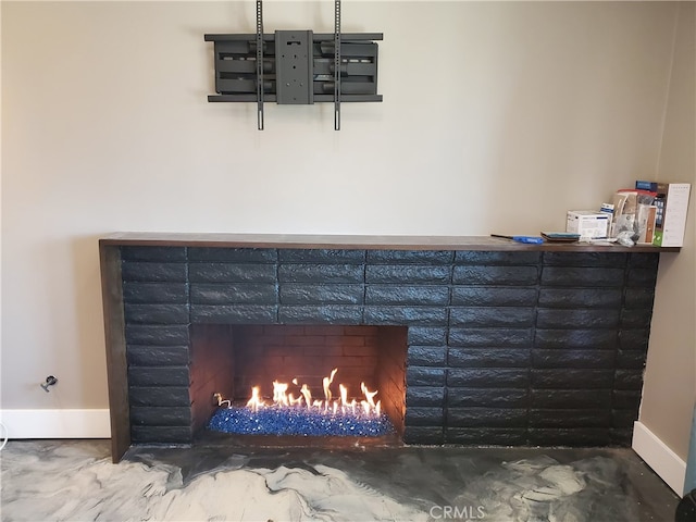 interior details featuring baseboards and a warm lit fireplace