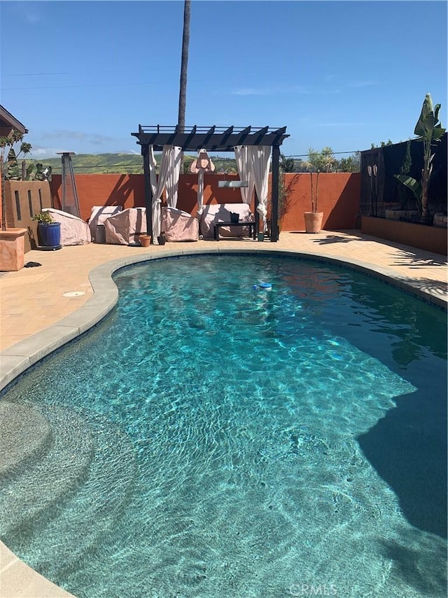 view of pool featuring a patio, fence, a fenced in pool, and a pergola