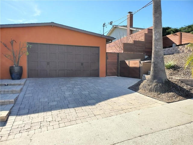 detached garage with fence and a gate