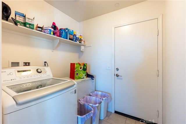 clothes washing area with light tile patterned floors and washer / dryer