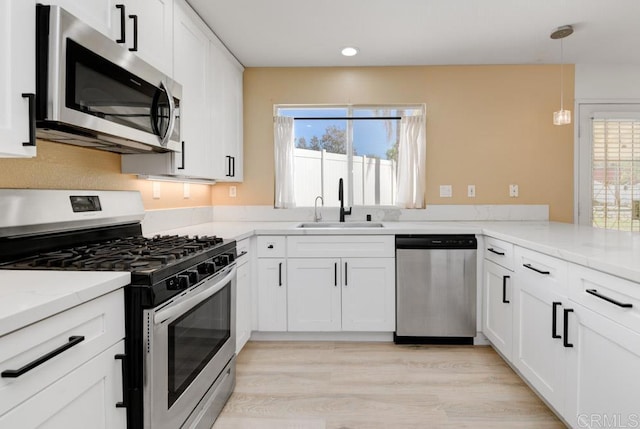 kitchen featuring light stone countertops, a healthy amount of sunlight, appliances with stainless steel finishes, and a sink