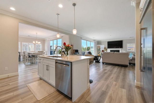 kitchen featuring white cabinetry, a kitchen island with sink, hanging light fixtures, sink, and dishwasher