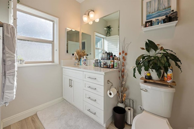 bathroom featuring toilet, wood-type flooring, and vanity