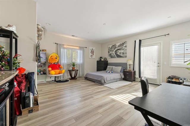 bedroom with light wood-type flooring and access to exterior