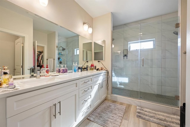 bathroom with wood-type flooring, an enclosed shower, and vanity