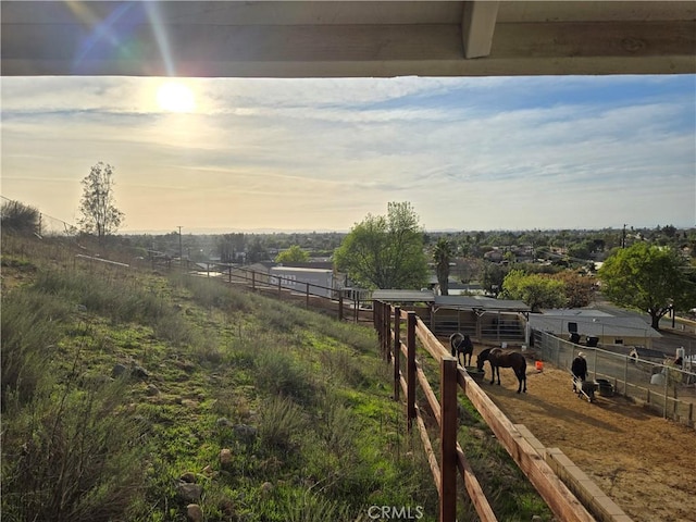 yard at dusk featuring a rural view and an outdoor structure