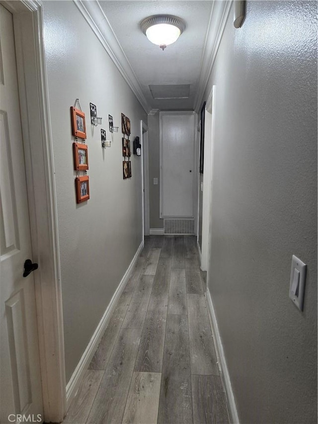 corridor with hardwood / wood-style flooring and crown molding