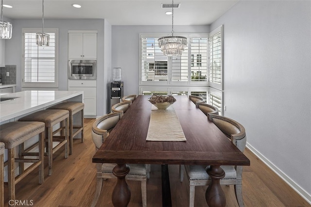 dining room featuring a notable chandelier and dark wood-type flooring