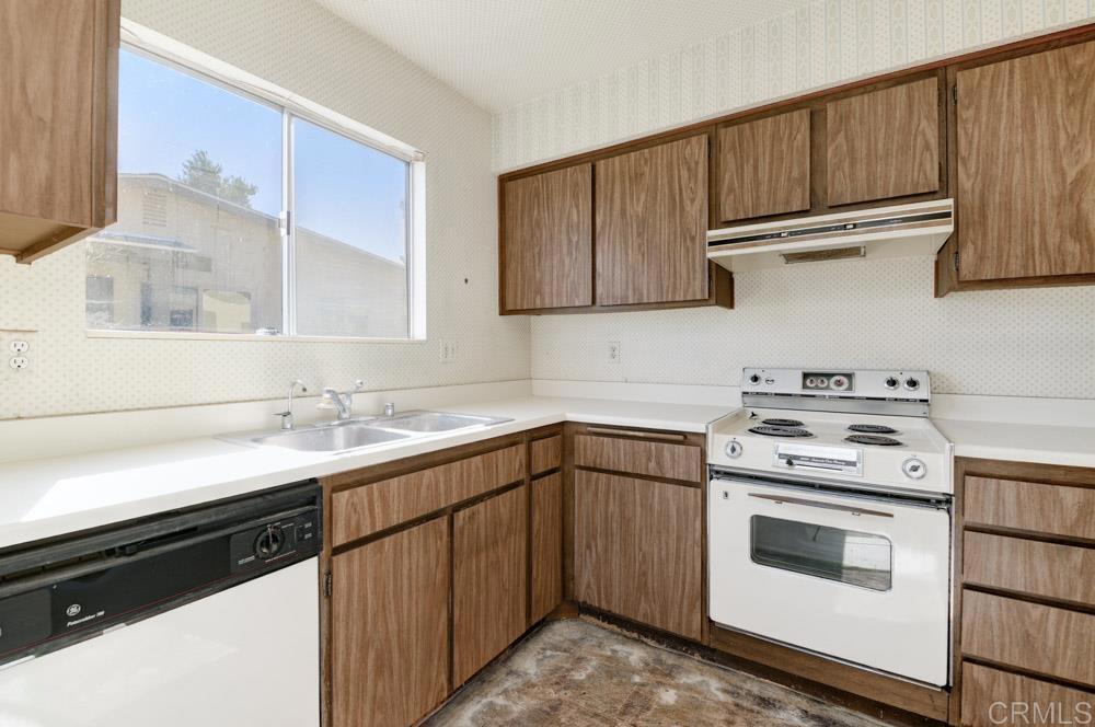 kitchen featuring sink, white appliances, and backsplash