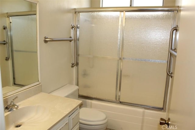 full bathroom with enclosed tub / shower combo, vanity, and toilet