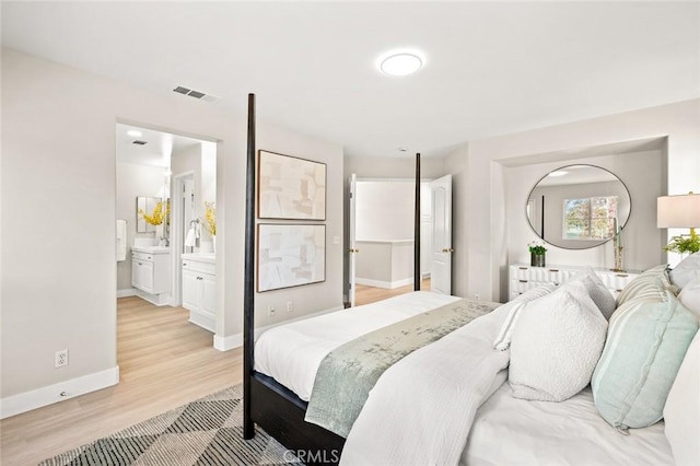 bedroom with light hardwood / wood-style floors and ensuite bath