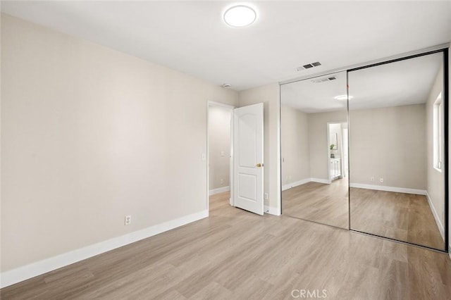 unfurnished bedroom with light hardwood / wood-style floors and a closet