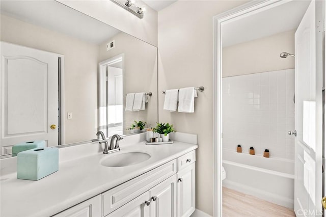 full bathroom with toilet,  shower combination, wood-type flooring, and vanity