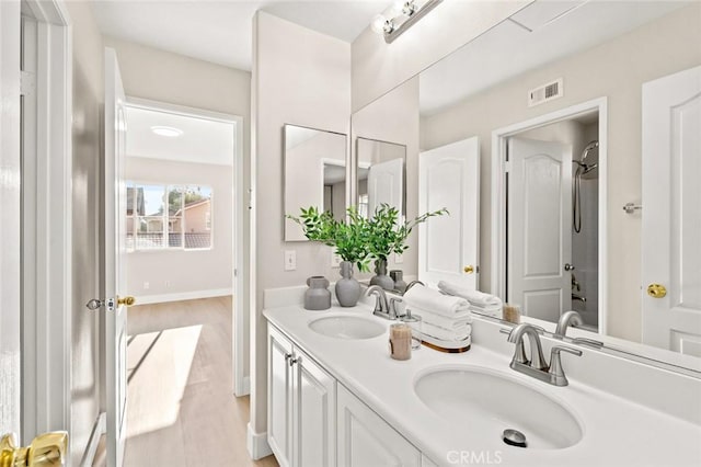 bathroom featuring  shower combination, vanity, and hardwood / wood-style flooring