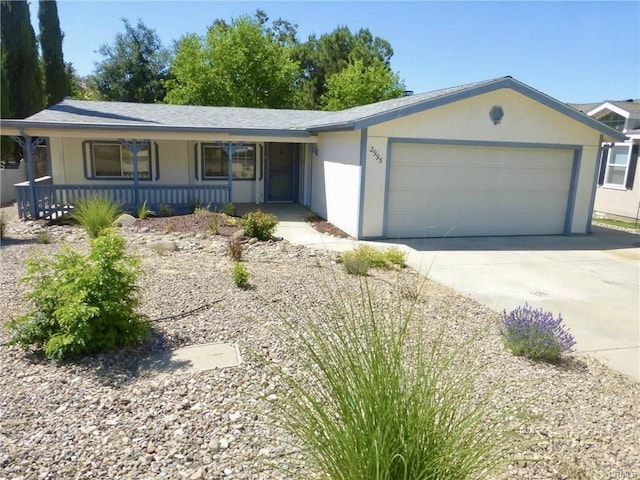 ranch-style house featuring a garage, covered porch, and driveway