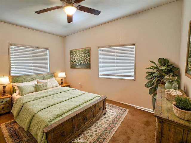 bedroom with dark colored carpet, a ceiling fan, and baseboards