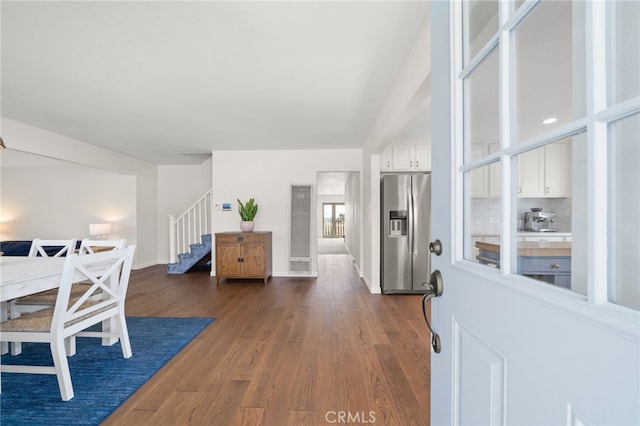 entrance foyer featuring dark wood-style flooring, stairway, and baseboards