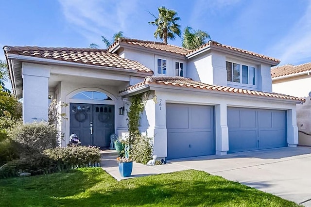 mediterranean / spanish house with a front lawn and a garage