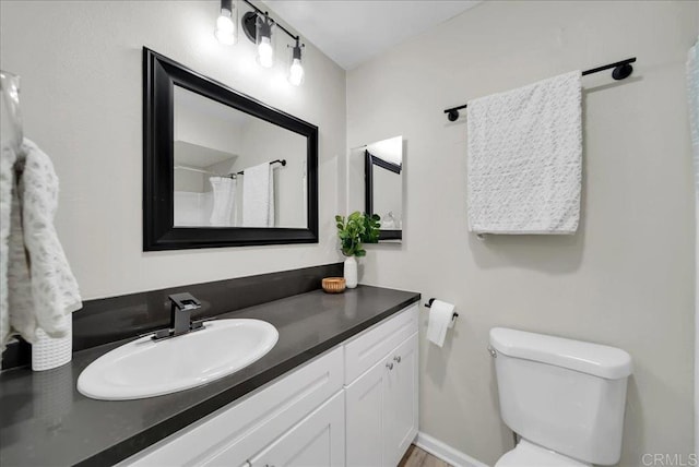 bathroom featuring vanity, a shower with shower curtain, and toilet