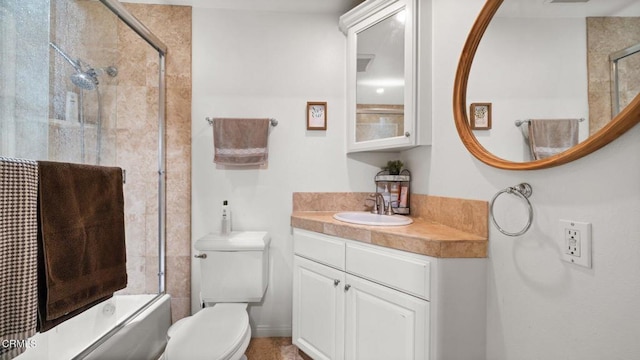 bathroom with combined bath / shower with glass door, vanity, and toilet