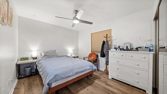 bedroom with light wood-style floors, baseboards, and a ceiling fan