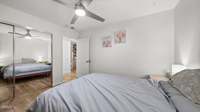 bedroom featuring light wood-style flooring, visible vents, ceiling fan, and a closet