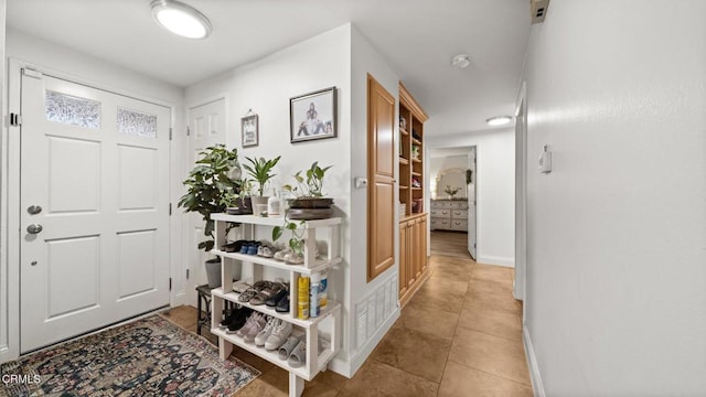 foyer with baseboards and light tile patterned floors