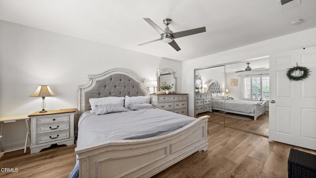 bedroom featuring light wood-type flooring, ceiling fan, visible vents, and a closet