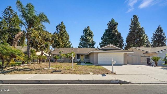 single story home with a garage, fence, driveway, stucco siding, and a front lawn