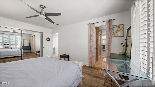 bedroom featuring a ceiling fan, a closet, baseboards, and wood finished floors