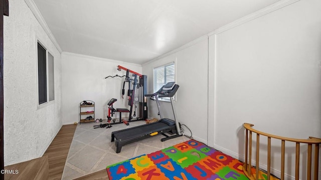 workout area with ornamental molding and wood finished floors