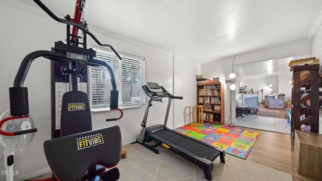 exercise area with baseboards and crown molding