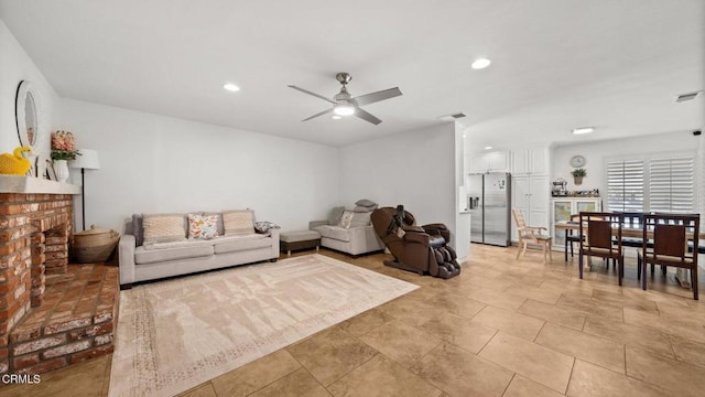 living room featuring ceiling fan, a fireplace, visible vents, and recessed lighting