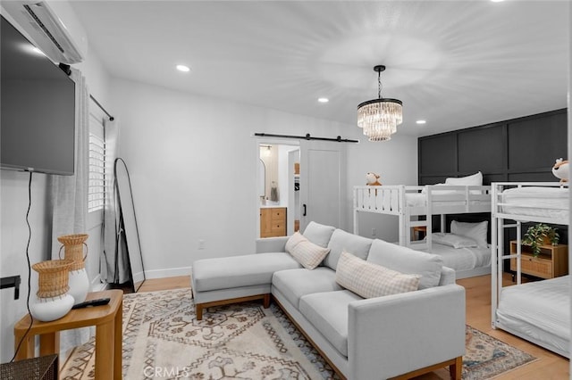 bedroom with a barn door, a notable chandelier, recessed lighting, baseboards, and light wood finished floors