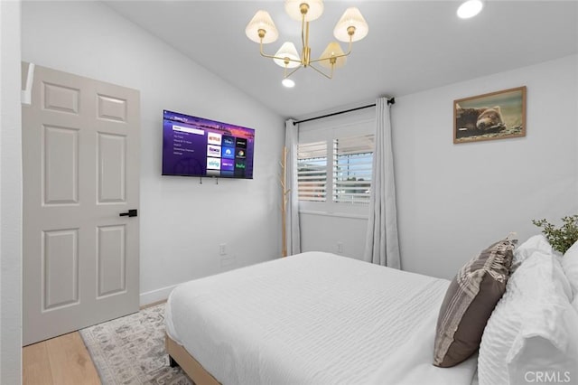 bedroom with lofted ceiling, recessed lighting, a notable chandelier, and wood finished floors