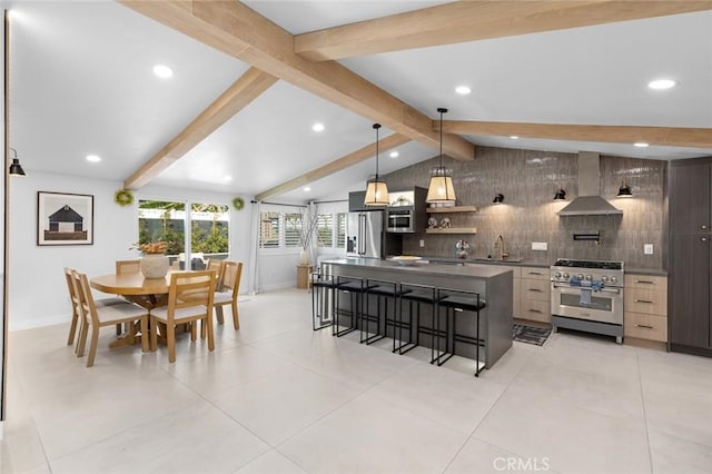 kitchen featuring high end appliances, dark countertops, wall chimney exhaust hood, modern cabinets, and decorative light fixtures