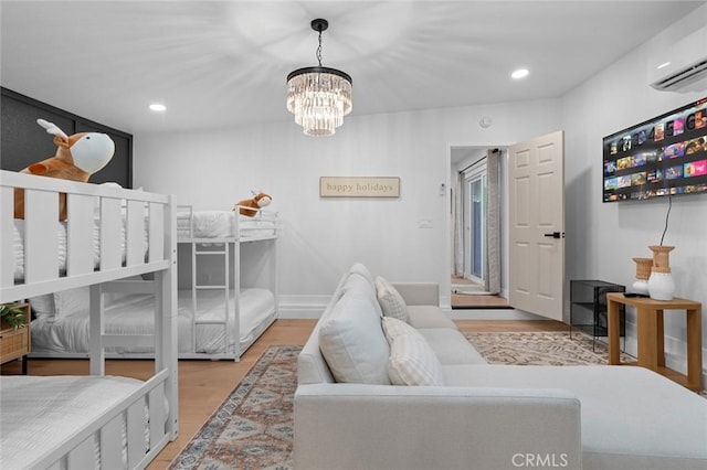 bedroom featuring a chandelier, light wood-style flooring, recessed lighting, baseboards, and a wall mounted AC