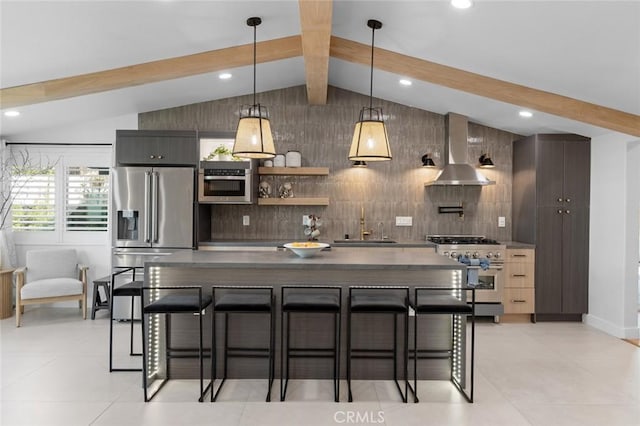 kitchen featuring a breakfast bar area, high quality appliances, wall chimney exhaust hood, dark countertops, and modern cabinets