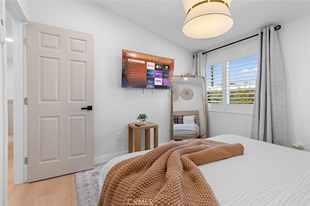 bedroom featuring lofted ceiling and light wood-type flooring