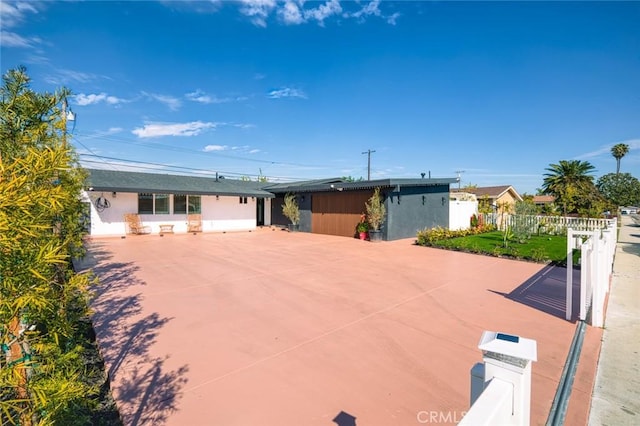 ranch-style home featuring fence